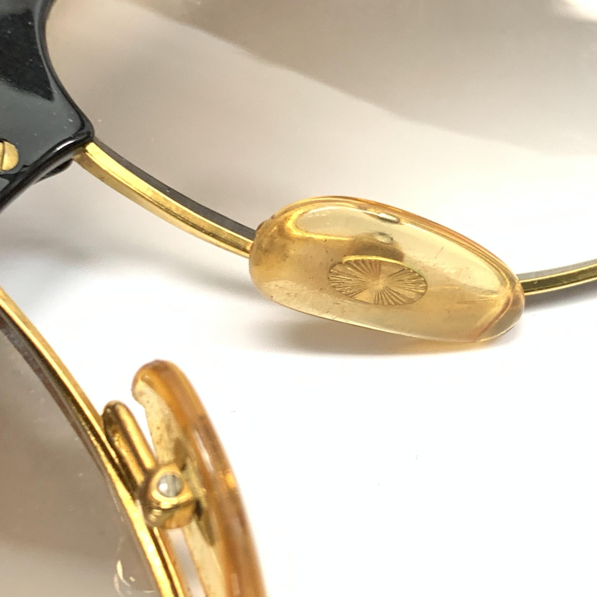 Gold rimmed glasses with a logo on the bridge