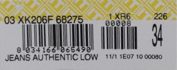 Yellow label on clothing item with black barcode and numbers