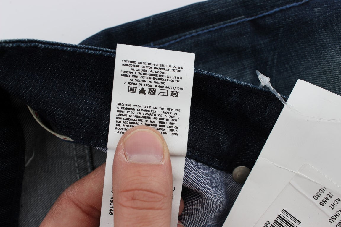 Hand holding a white tag on blue jeans