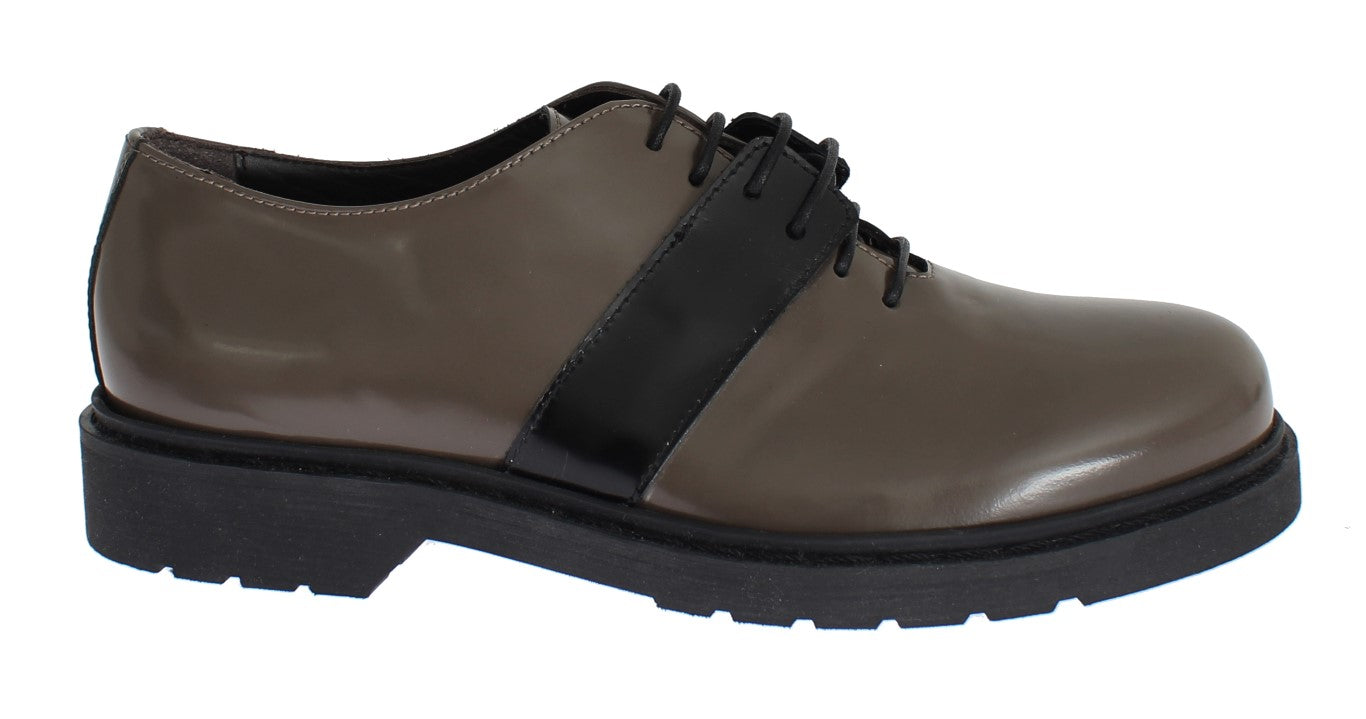 Brown leather shoes with black laces and a white stripe on the side