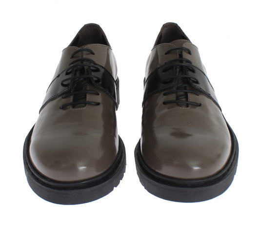 Pair of brown leather shoes with black laces and soles