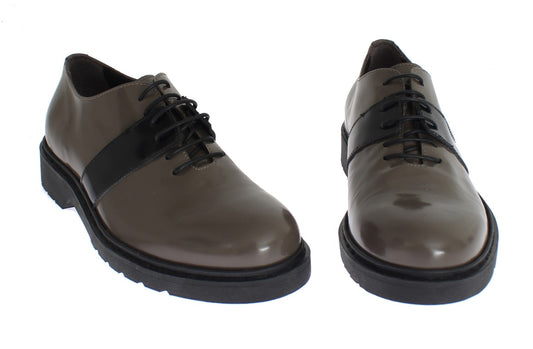 Pair of brown dress shoes with laces and a shiny finish