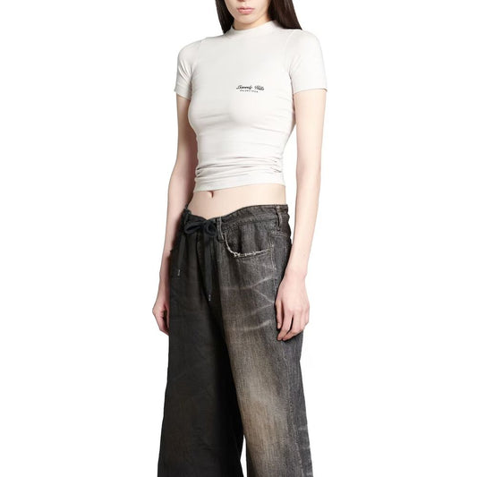 Woman wearing white crop top and blue jeans