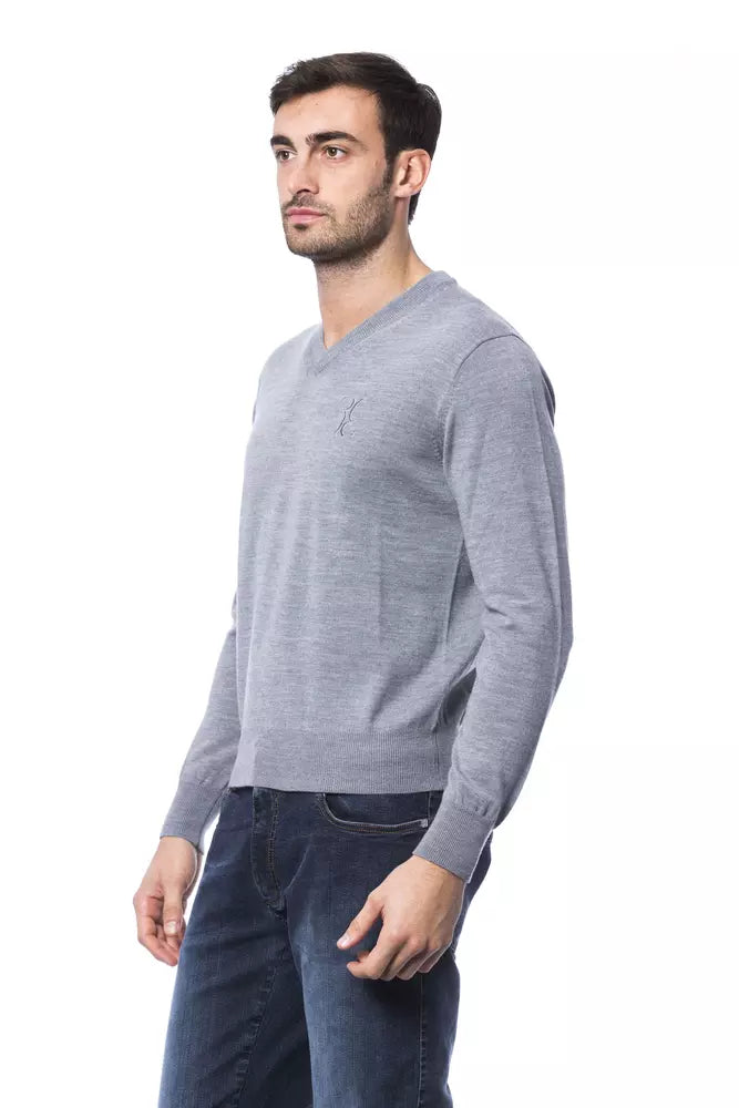 Man wearing gray sweater and blue jeans