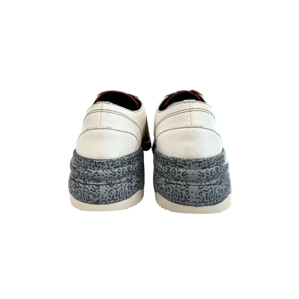 Pair of women's sneakers with blue patterned laces, beige leather upper and white soles