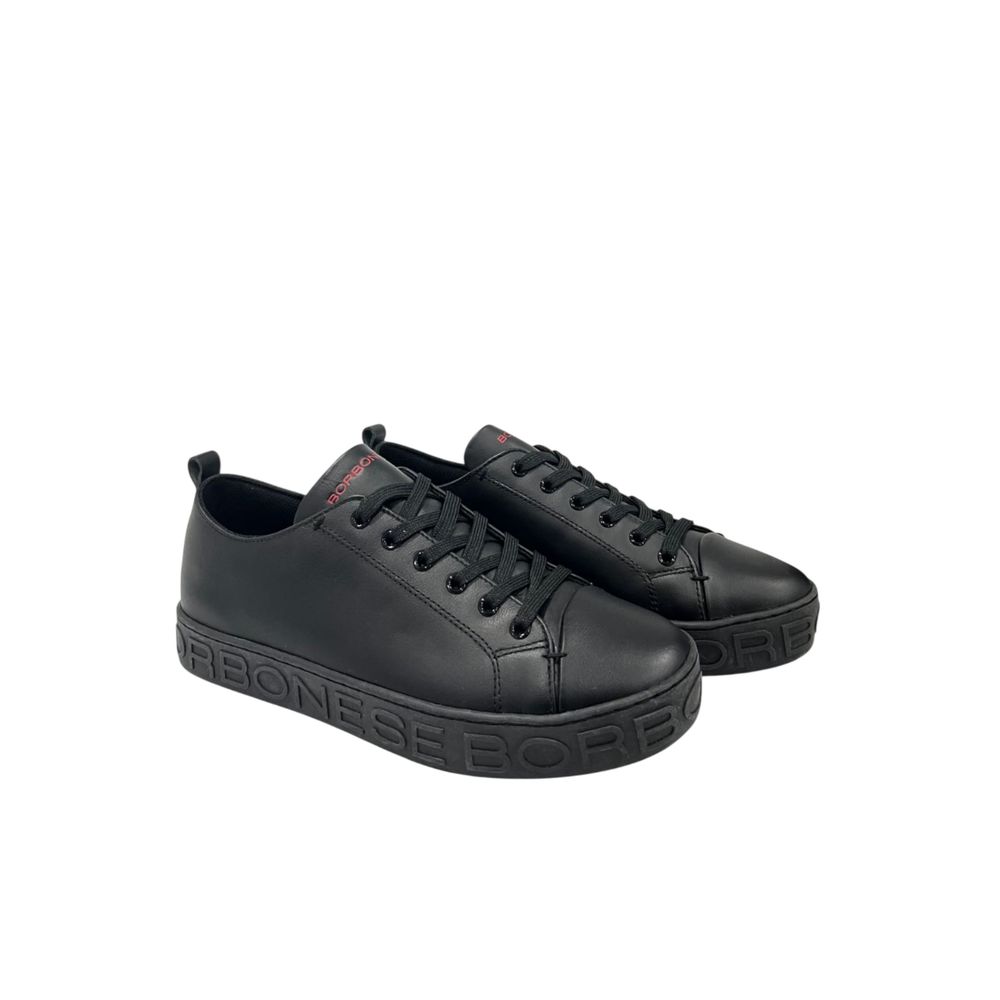 A pair of black leather men's sneakers with white laces, featuring a red logo on the side and a flat sole