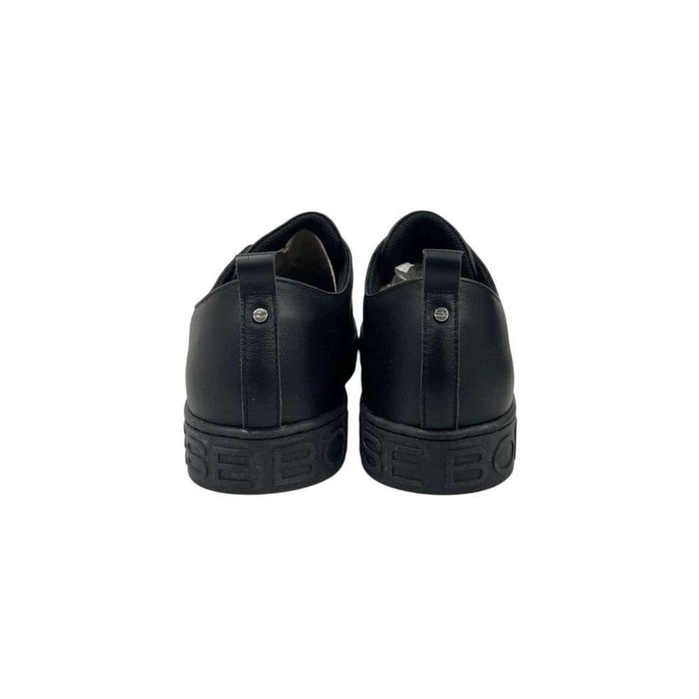 Pair of black leather men's sneakers with laces, featuring a low-top design and visible stitching