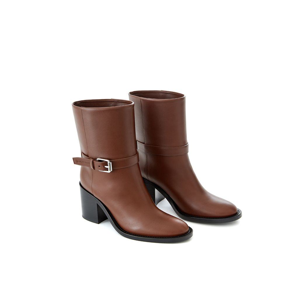 Pair of brown leather boots with a buckle on the side