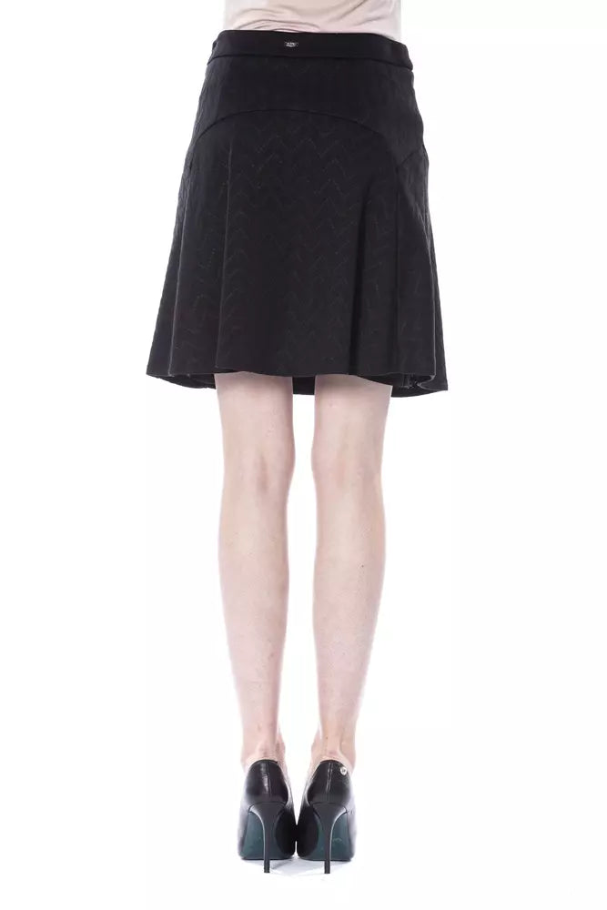Black pleated skirt worn by a person standing against white background