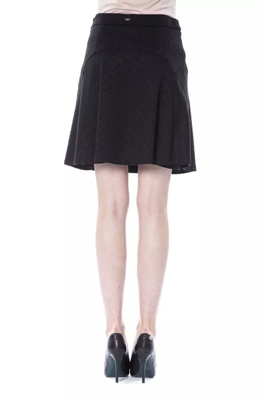 Black pleated skirt worn by a person standing against white background