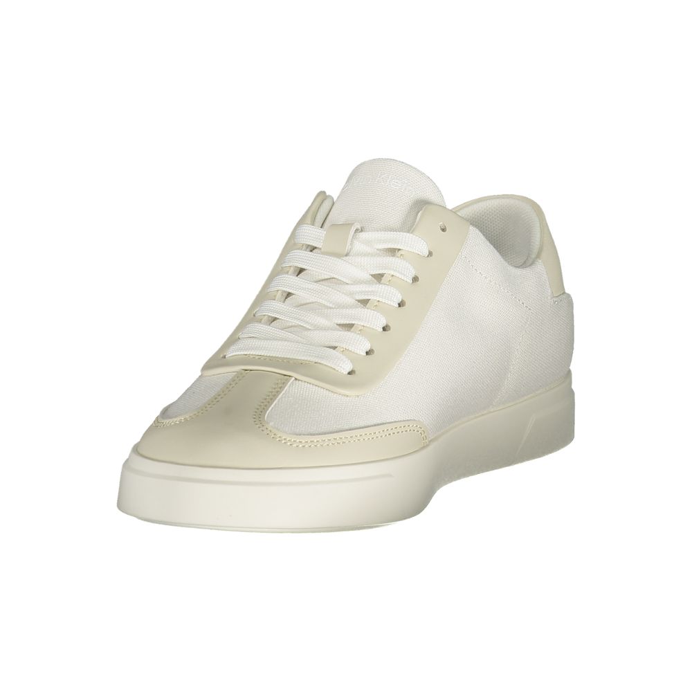 A woman's white sneaker with a lace-up front, featuring a textured upper and a flat sole