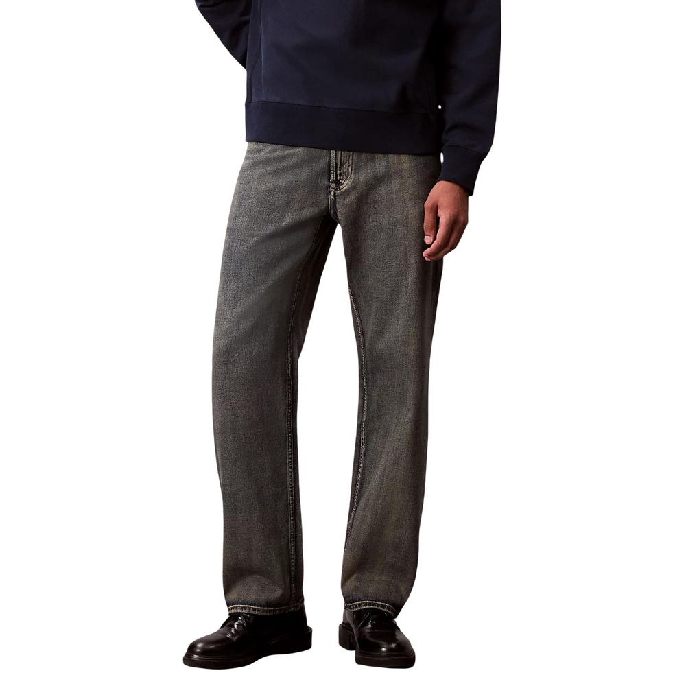 Man wearing blue sweater and jeans standing against white background