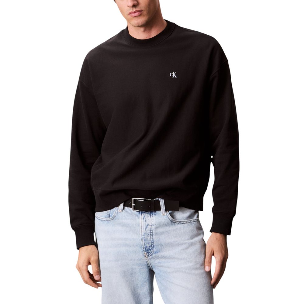 Man wearing black sweatshirt and blue jeans