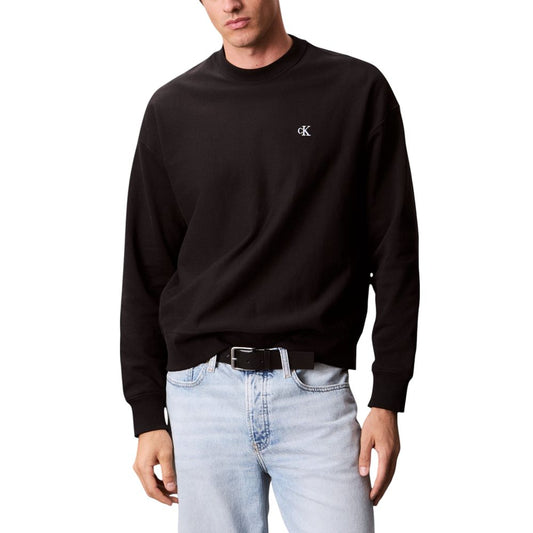 Man wearing black sweatshirt and blue jeans