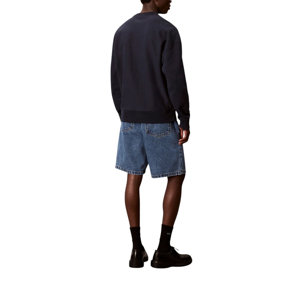 Man wearing blue sweatshirt and denim shorts