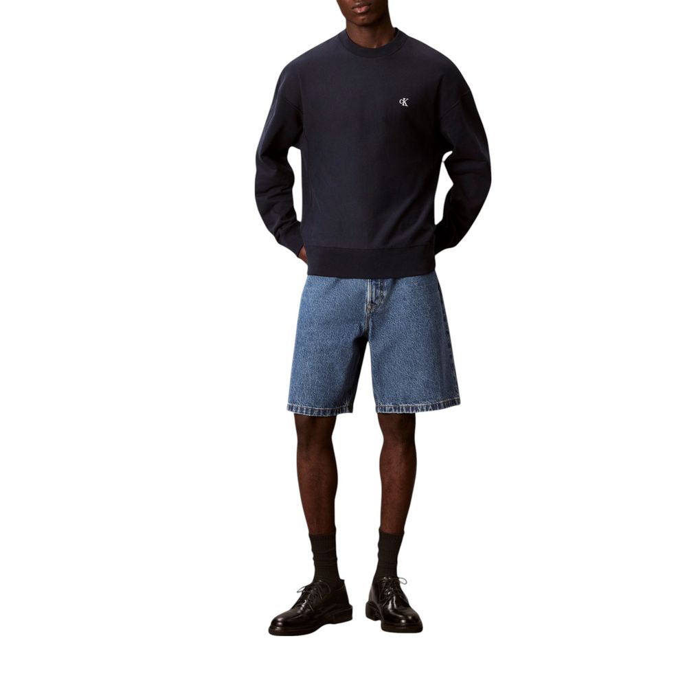 Man wearing blue sweatshirt and denim shorts