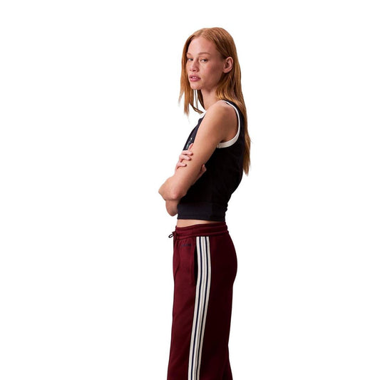 Woman wearing black tank top and red pants with white stripes