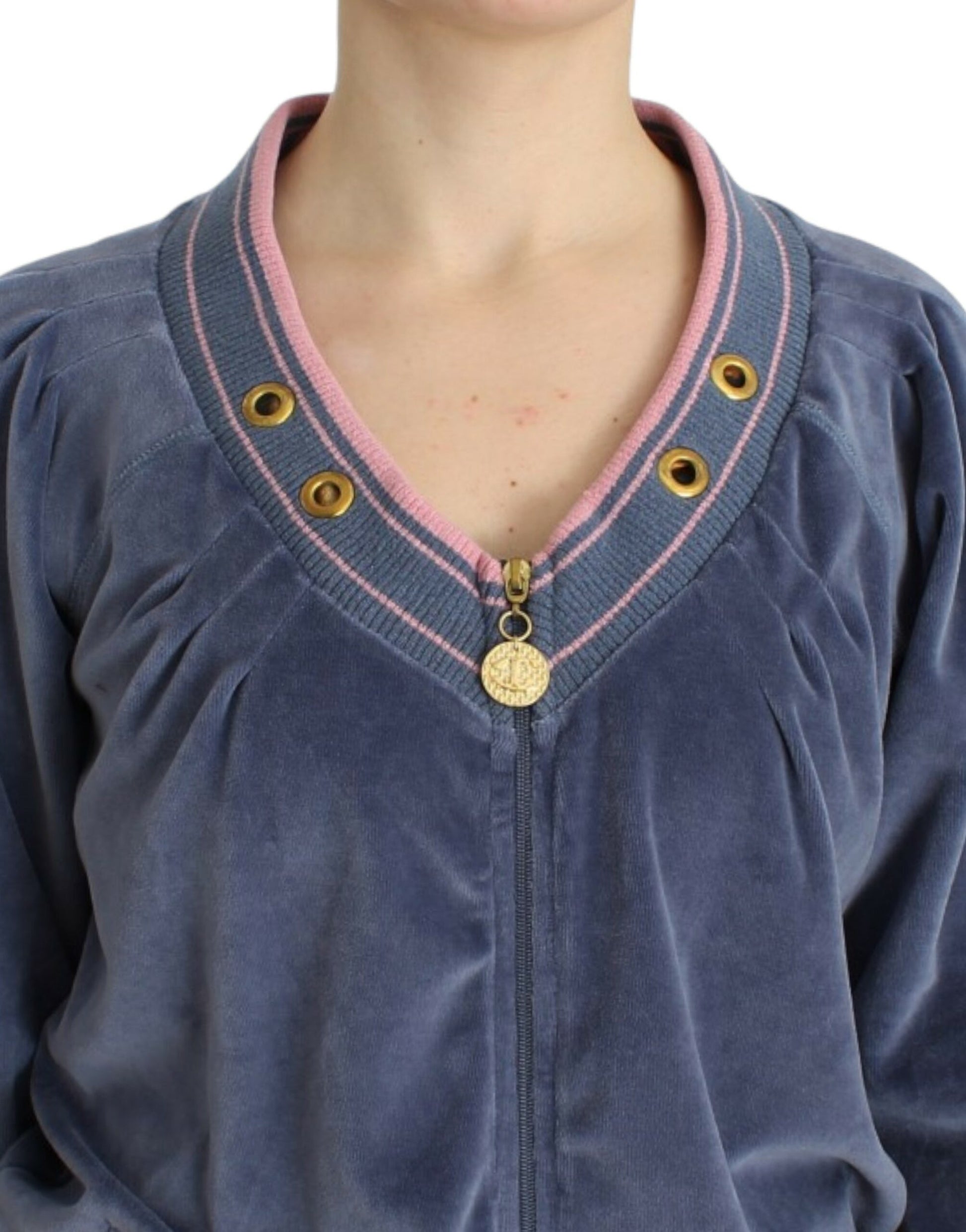 Woman wearing blue velvet sweater with pink trim and buttons