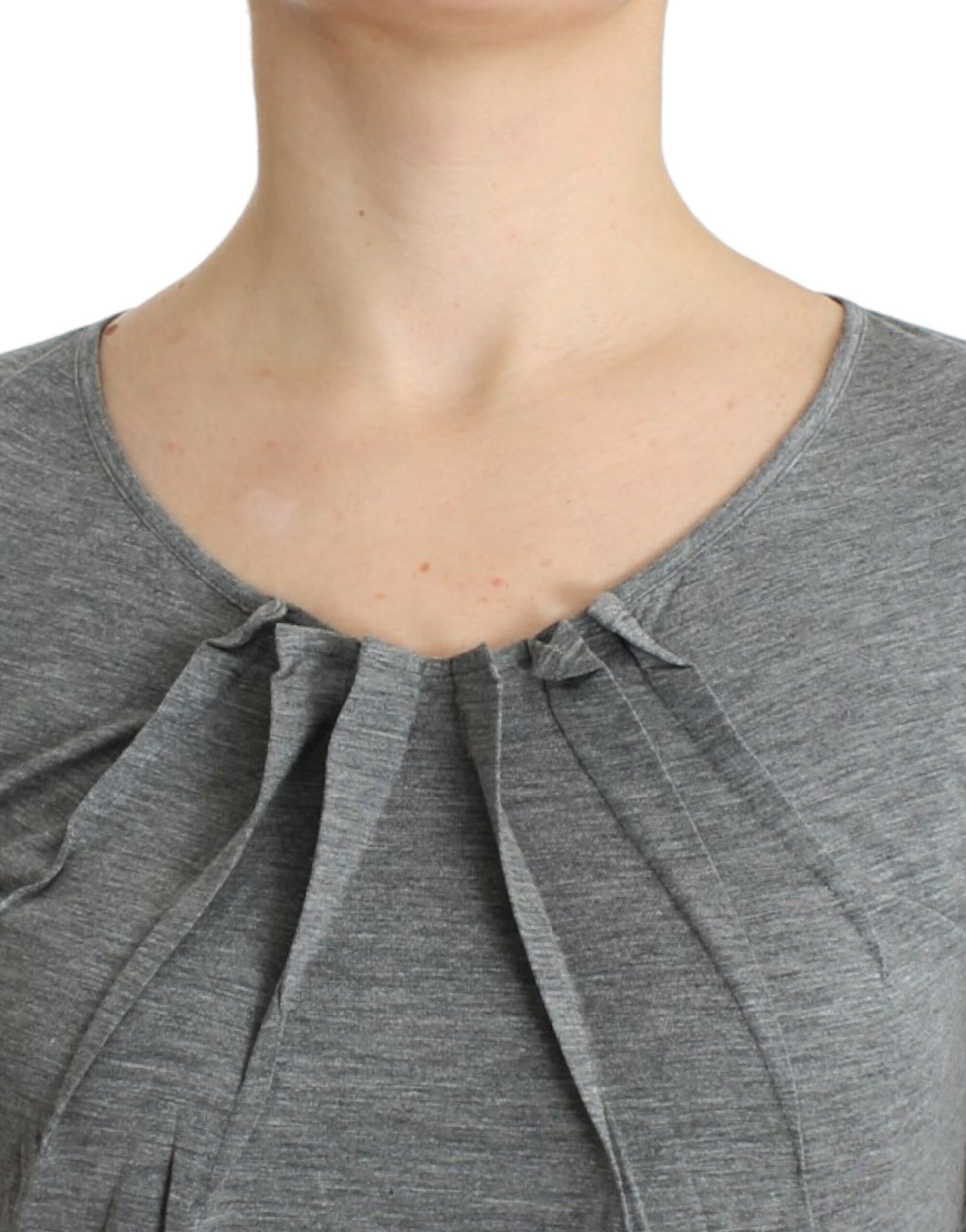 Woman wearing gray blouse with ruffled neckline