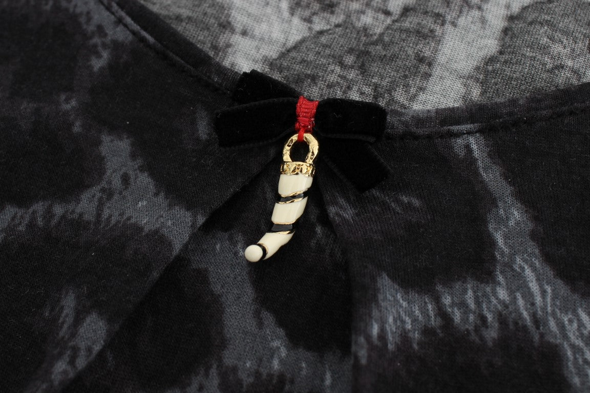 Black and white patterned fabric with a gold zipper pull featuring a small figurine
