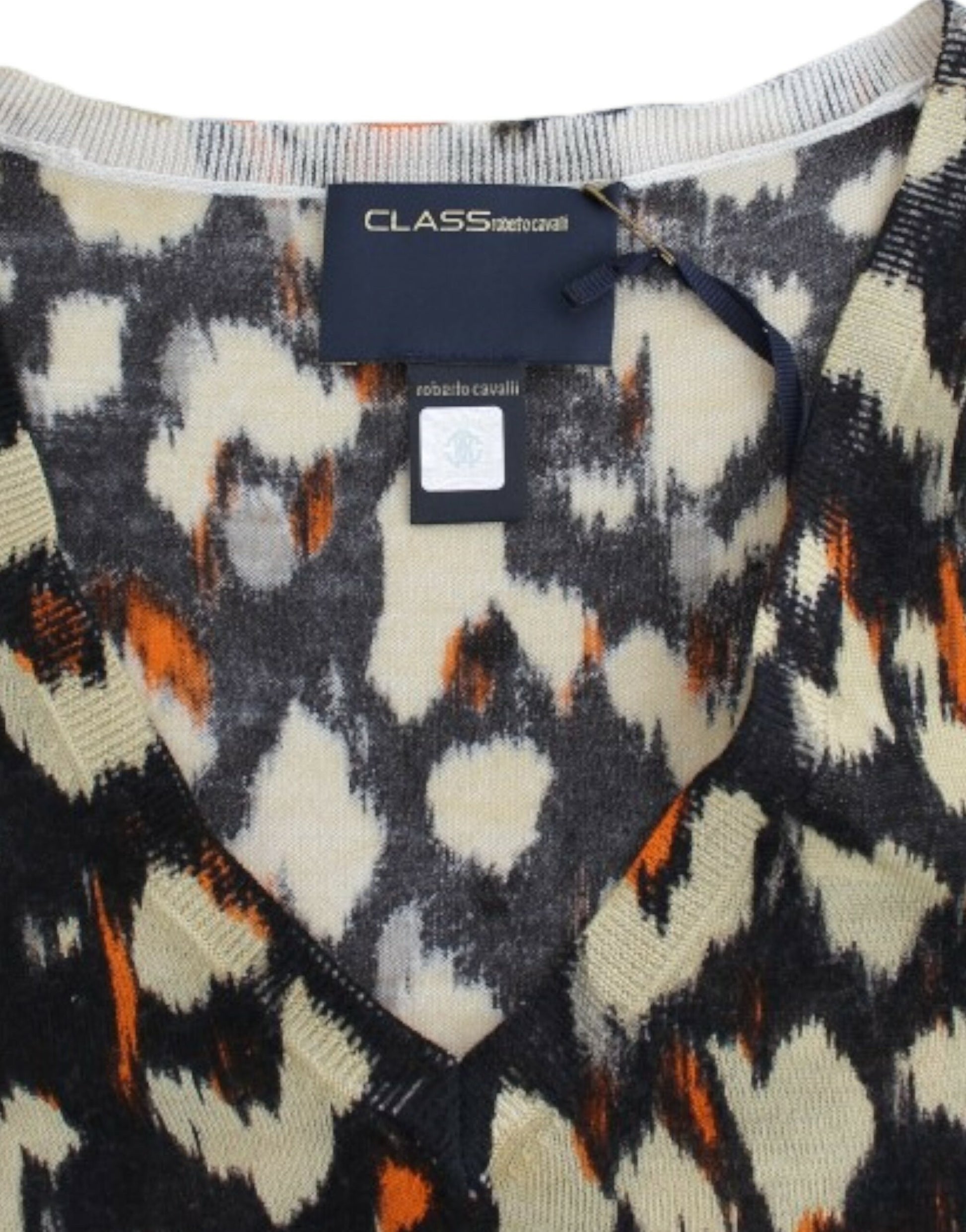 Knit sweater with geometric pattern in shades of orange, yellow, and black
