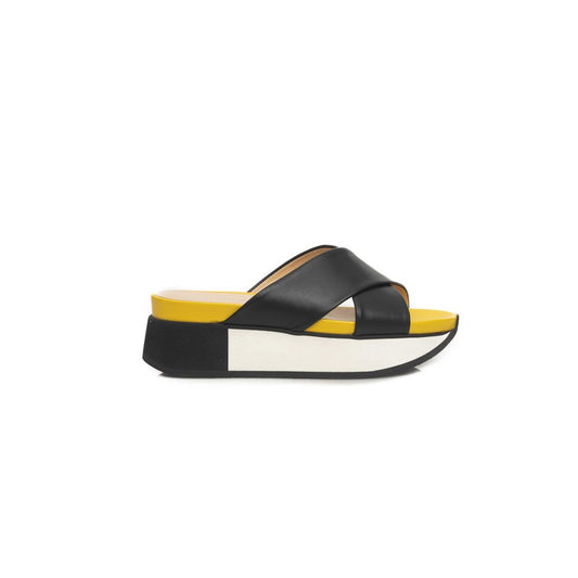 Yellow and black sandal with strap over foot