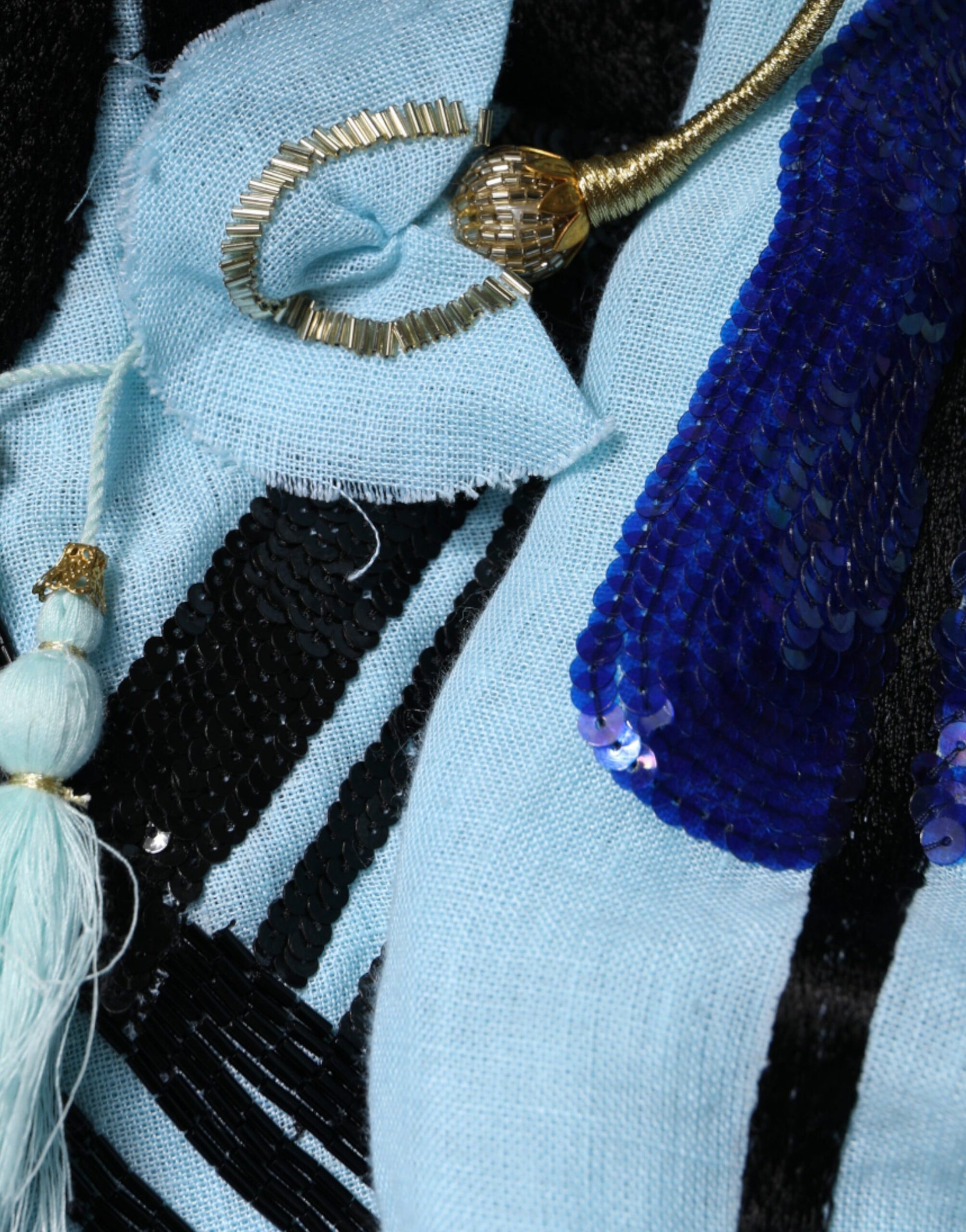 A light blue floral embellished maxi dress with a gold necklace and earrings