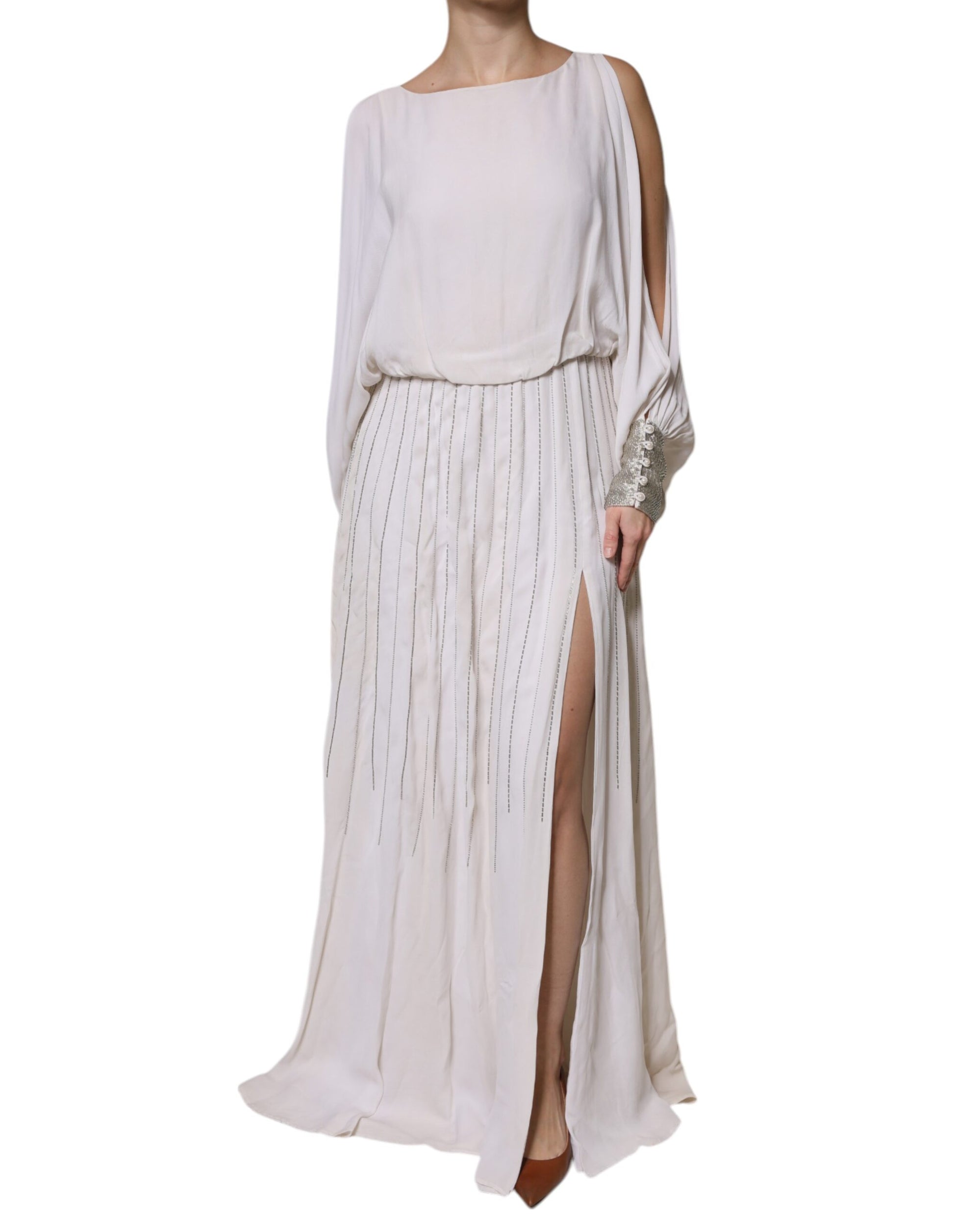 A long off-white maxi dress with embellishments and a high slit on the side