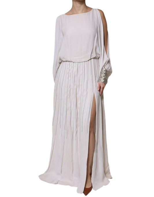 A long off-white maxi dress with embellishments and a high slit on the side