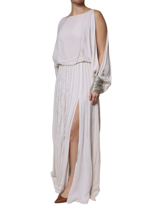 A long off-white maxi dress with embellishments and a high slit on the side
