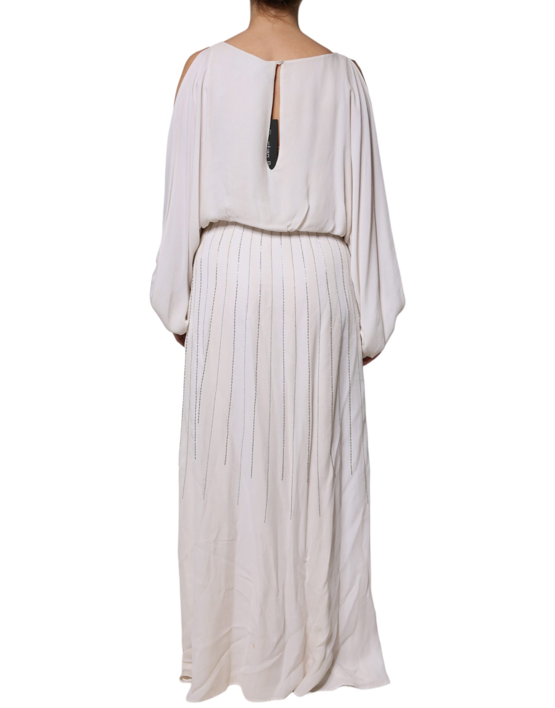 A long off-white maxi dress with embellishments and a deep V neckline