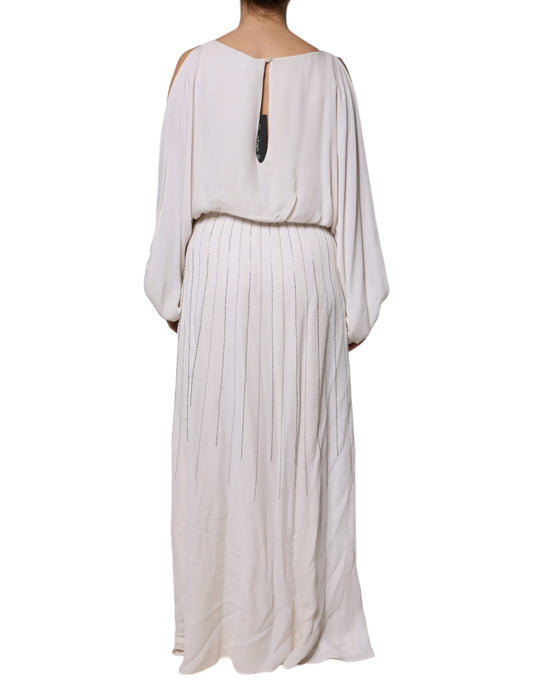 A long off-white maxi dress with embellishments and a deep V neckline