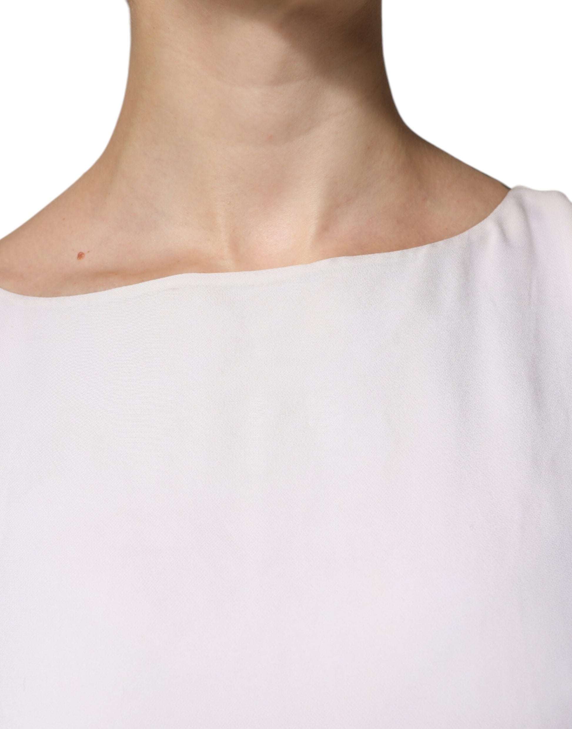 A long white dress with embellishments on the neckline and sleeves