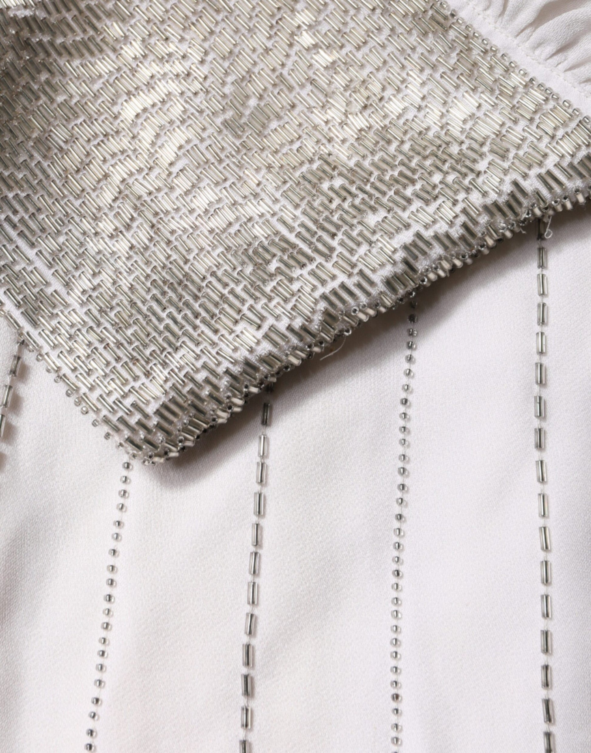 A long white dress with gold sequin embellishments