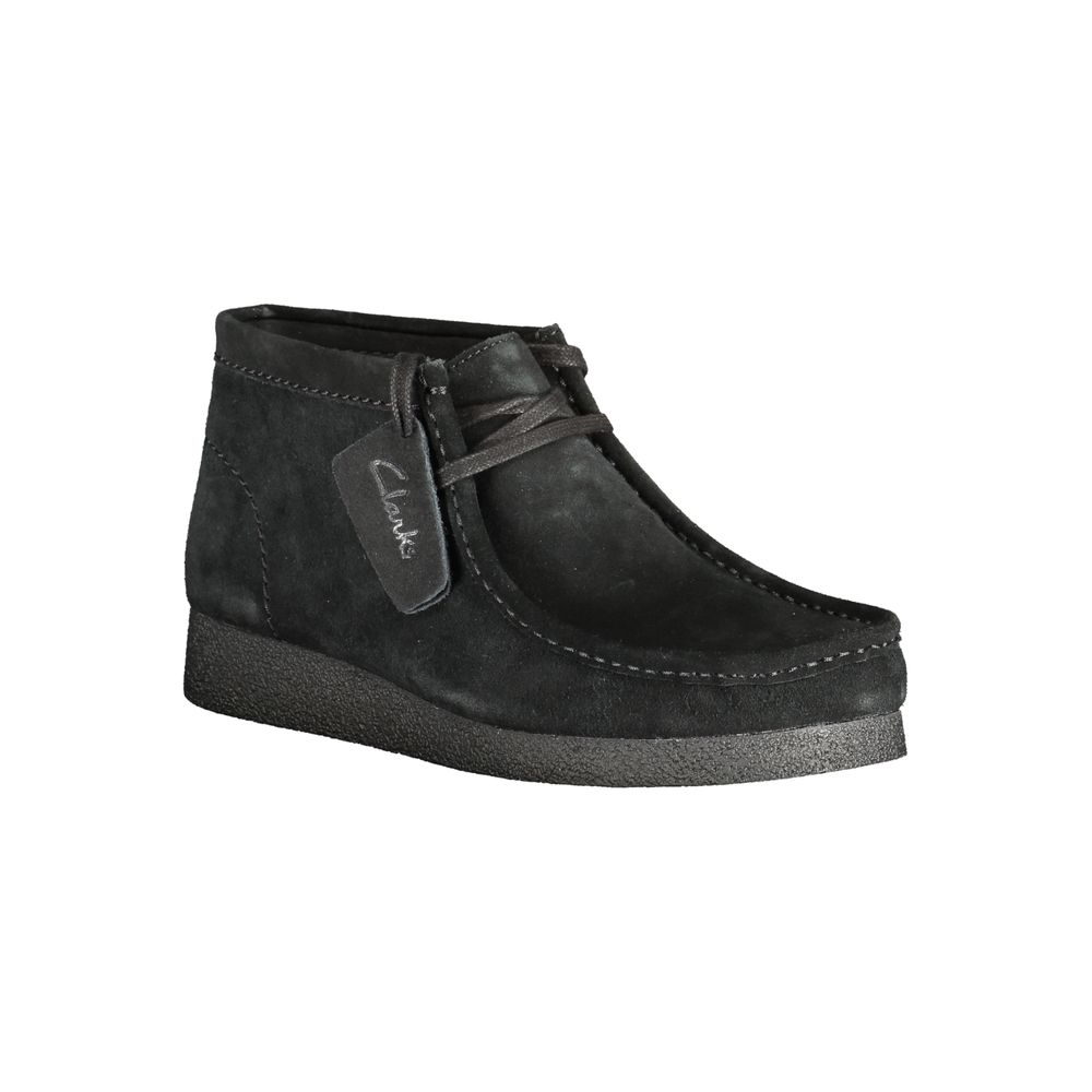 A black leather men's sneaker with a rubber sole, featuring a label on the side that reads "Clarks