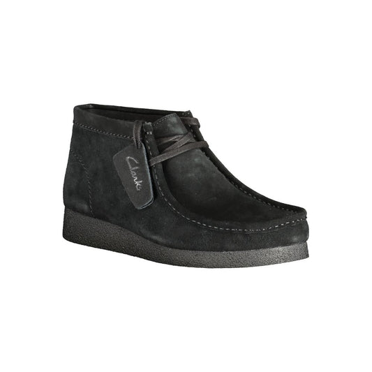 A black leather men's sneaker with a rubber sole, featuring a label on the side that reads "Clarks