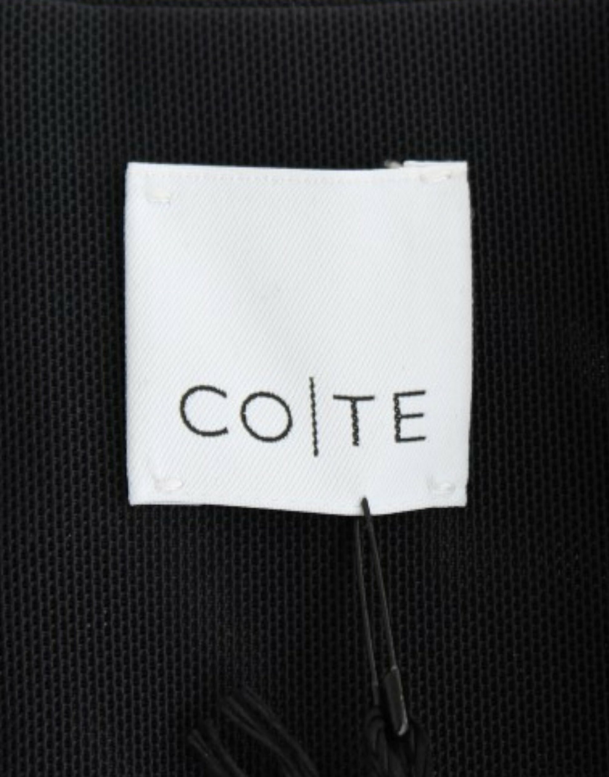 Black fabric with white label that reads "COTE"