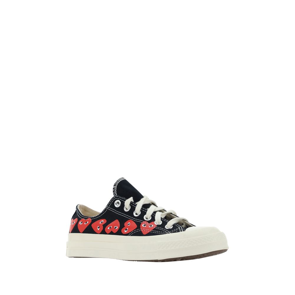 A pair of black canvas shoes with red hearts, featuring a high top design and laces