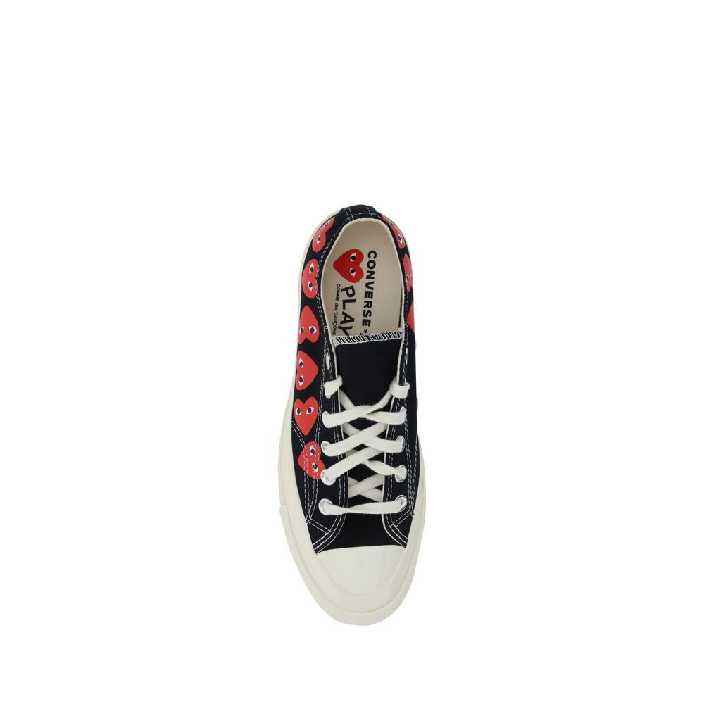A pair of black canvas sneakers with white laces and a heart pattern on the side