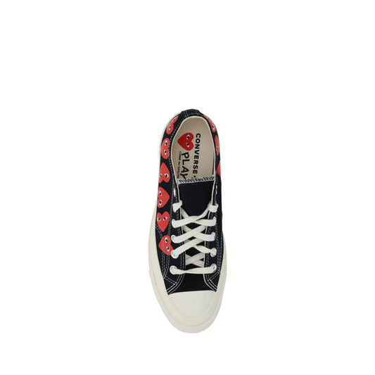 A pair of black canvas sneakers with white laces and a heart pattern on the side