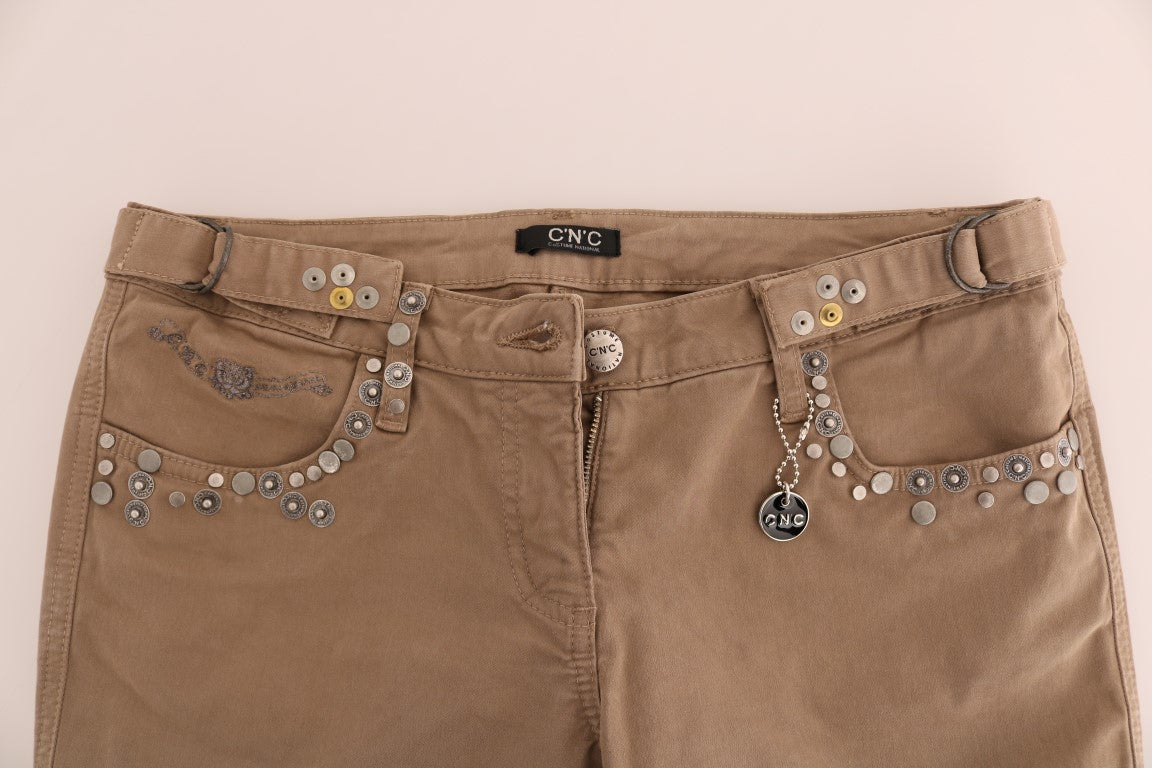 Brown denim jeans with embellishments on front pockets