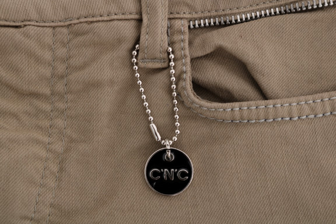 Silver chain necklace with black tag hanging from pocket of khaki pants
