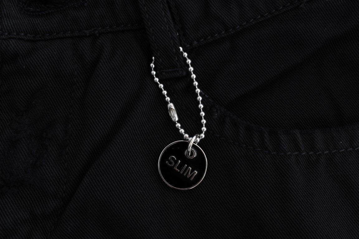 Silver necklace with a pendant on black denim jeans