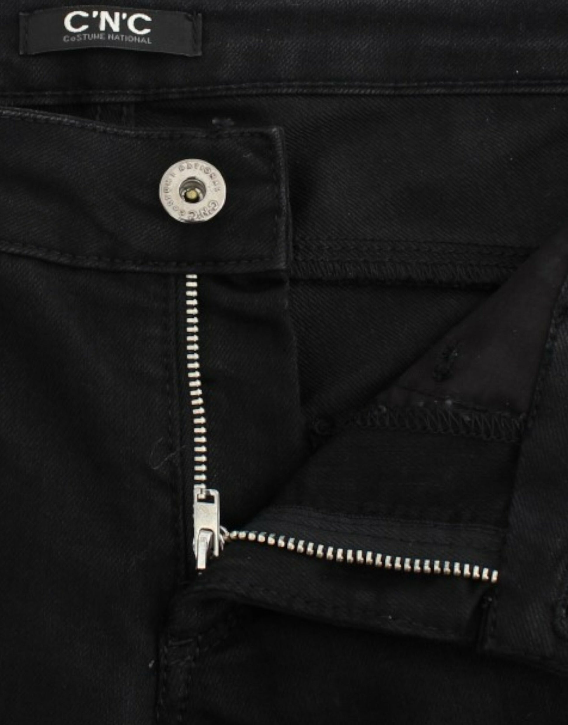 Pair of black jeans with silver zipper and studs on side seam