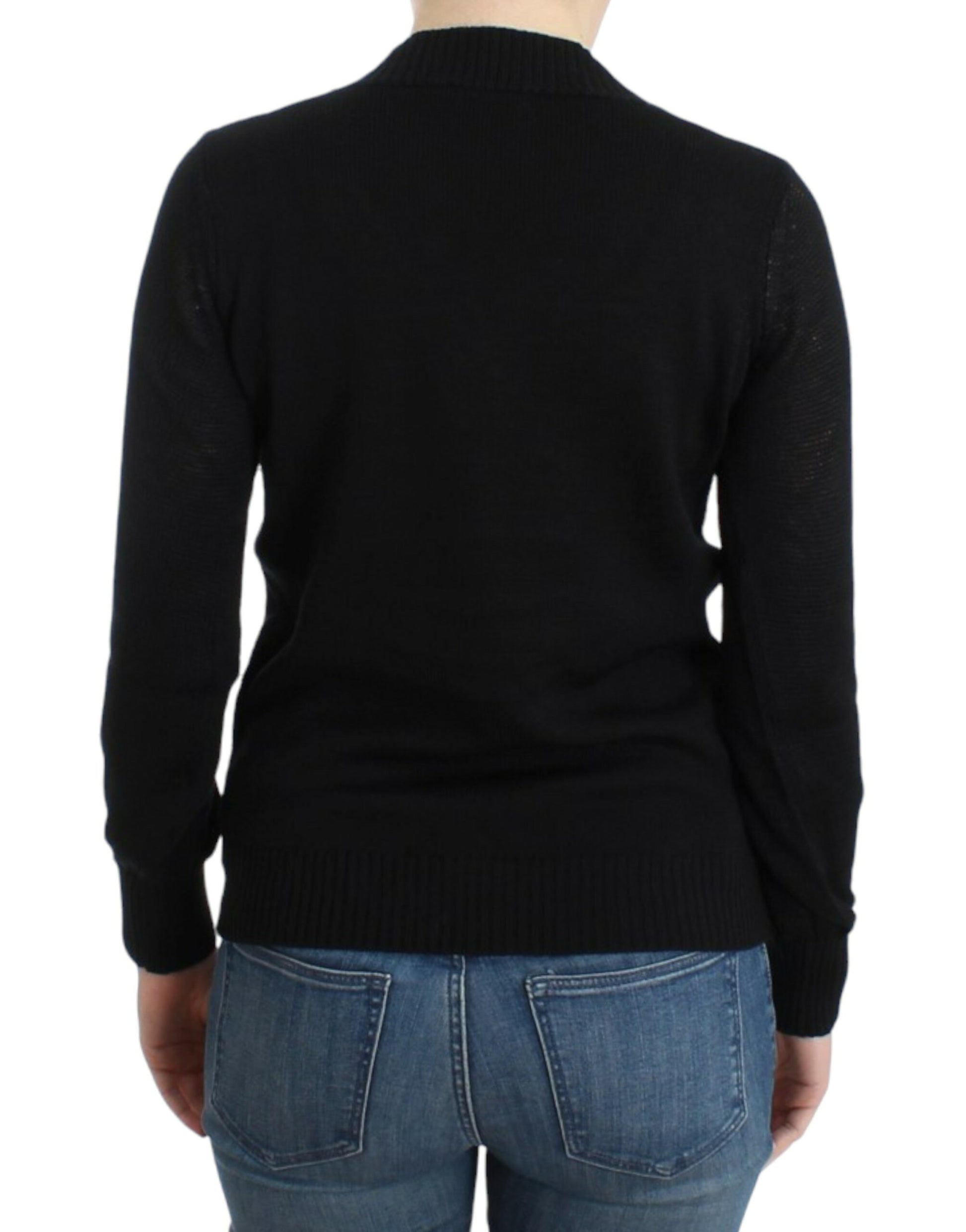 Black sweater on a person wearing blue jeans