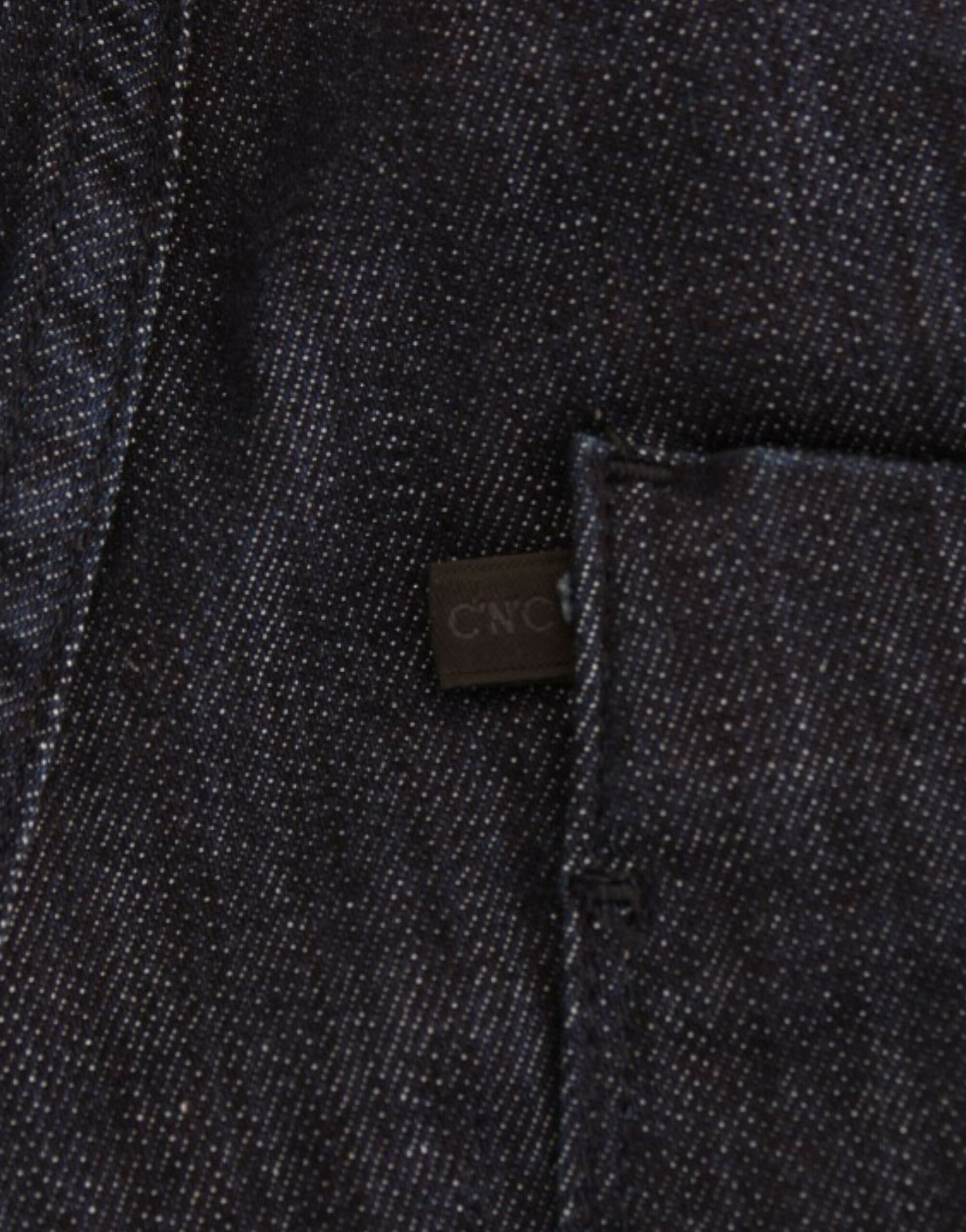 A close-up of a denim jeans pocket with a tag visible on it. The tag has the letters C&A printed on it