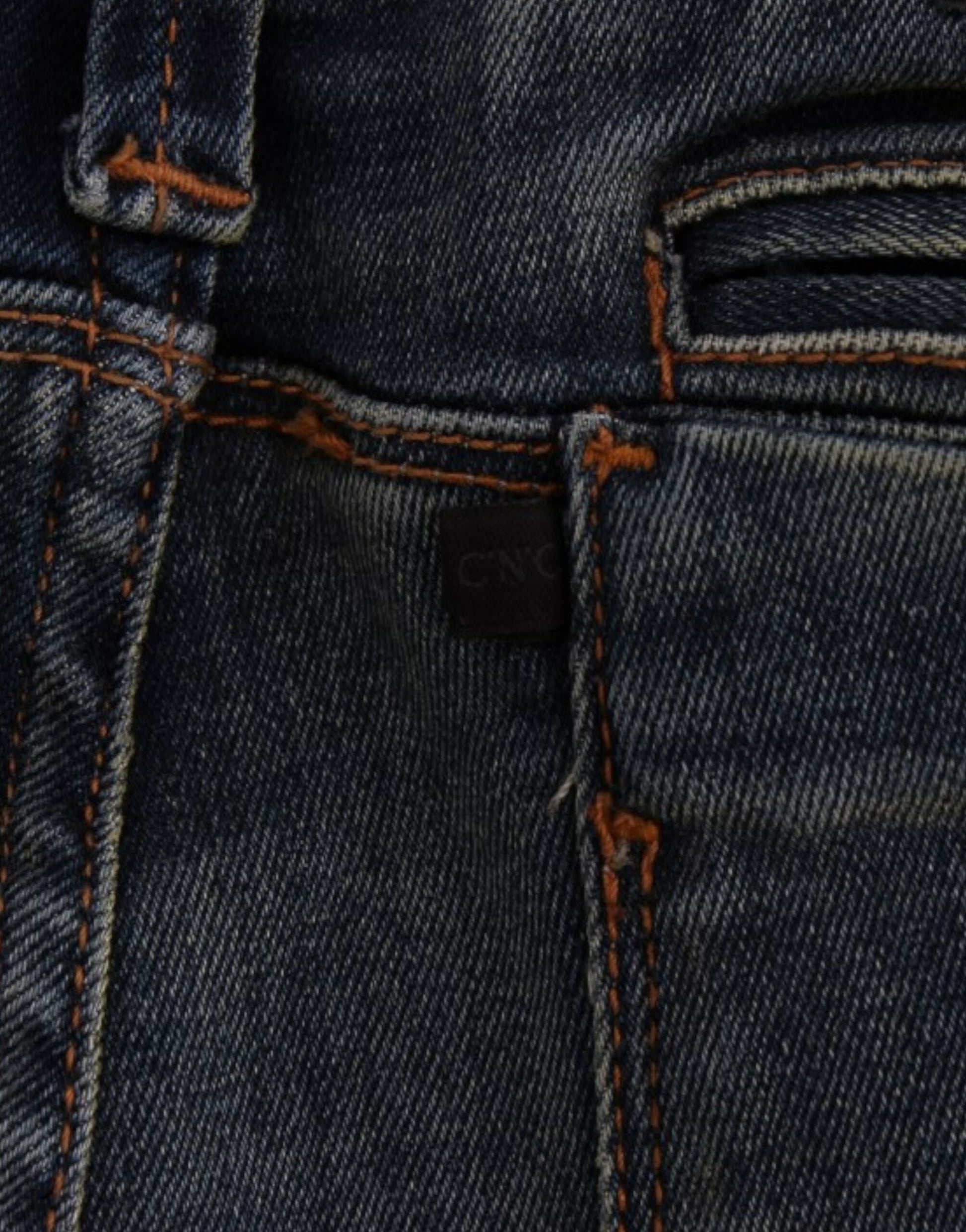Blue denim jeans with orange stitching and a small black tag on the waistband