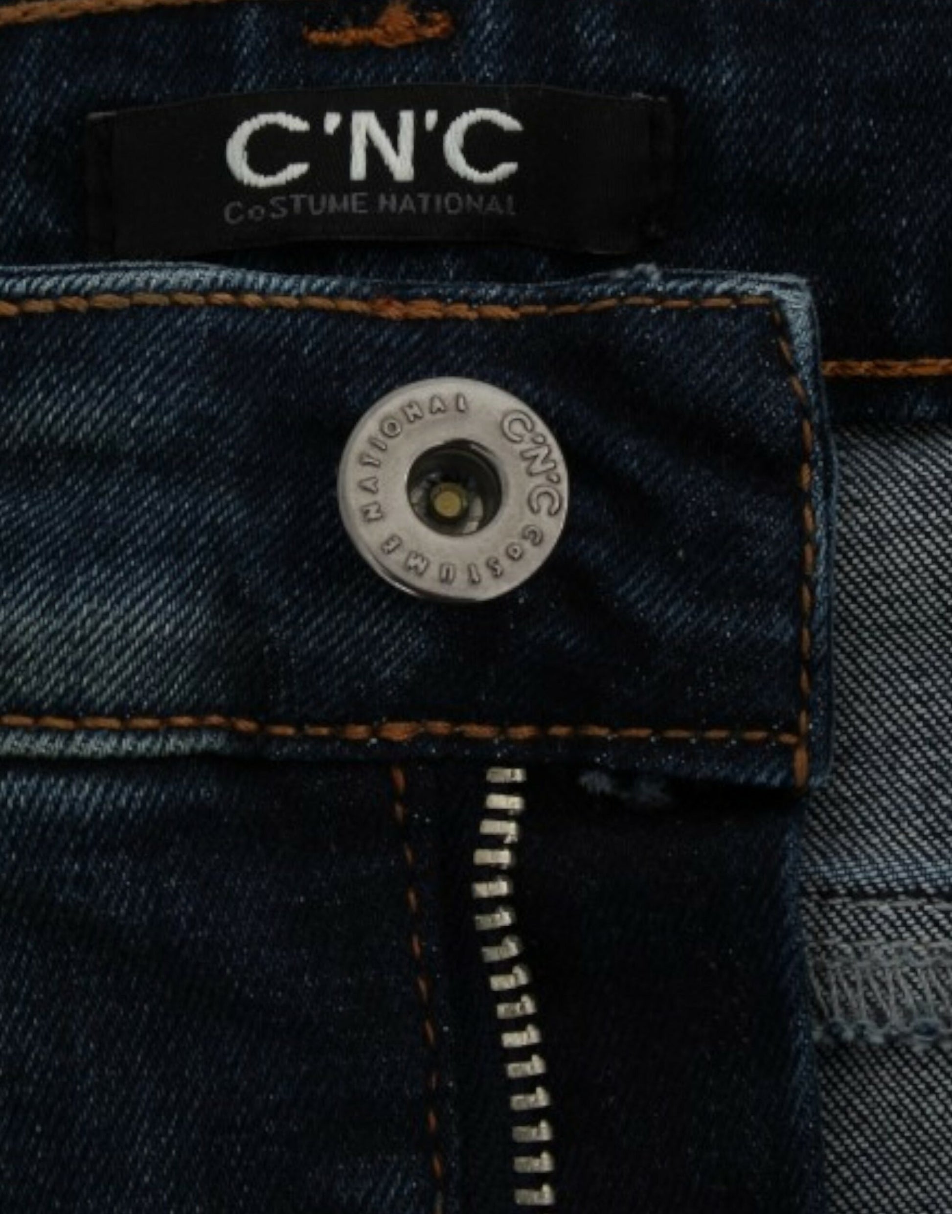 Pair of blue jeans with a camera lens on the back pocket
