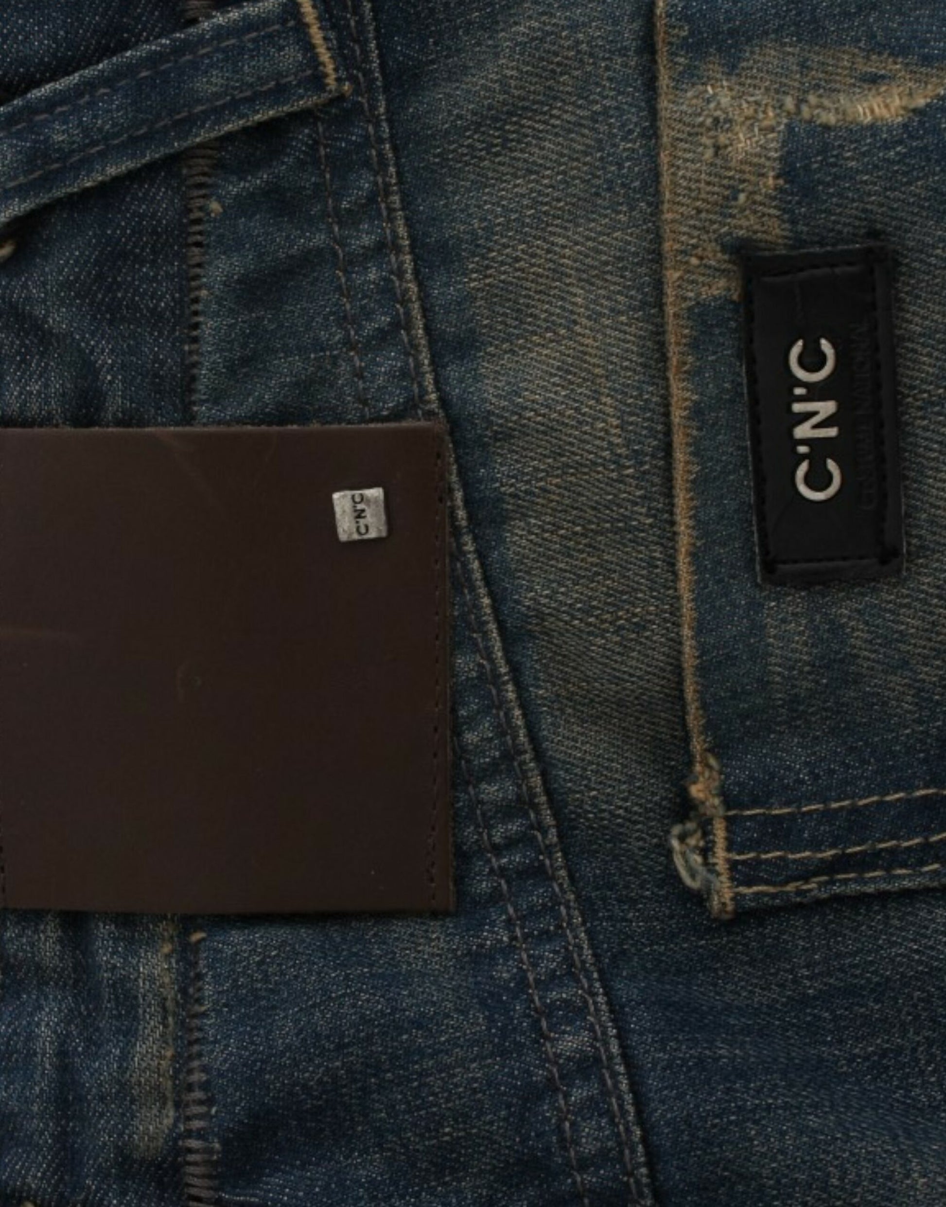 Blue denim jeans with brown leather patch on back pocket and white label inside waistband