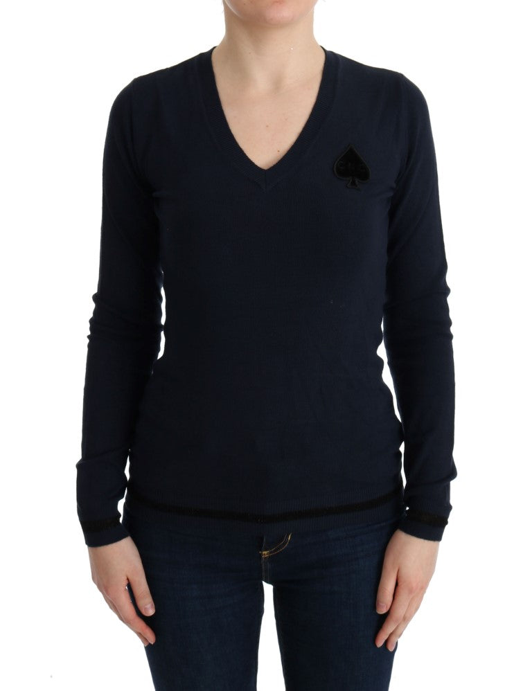 Woman wearing dark blue sweater with a card symbol on left chest